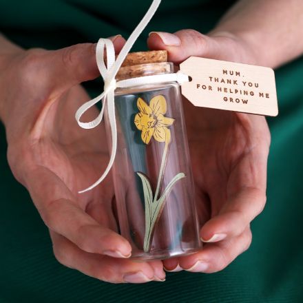 Miniature wooden daffodil in 10cm glass bottle with engraved message tag reading 'Mum, thank you for helping me grow' attached with ribbon.