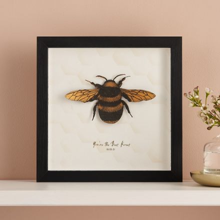 3D paper cut honey bee mounted on white card and framed in black box frame.