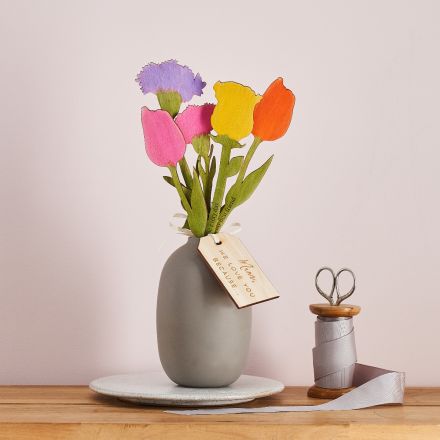 Bunch of wooden flowers with blooms in different colours. Each stem has a personalised engraved message.