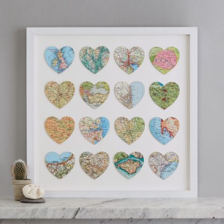 Sixteen personalised map location hearts in white box frame on marble mantelpiece