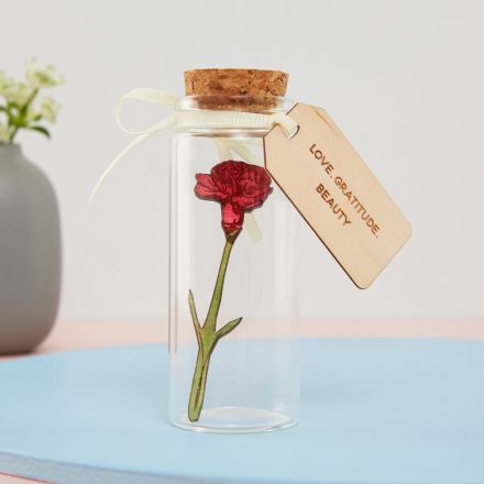 Miniature wooden daffodil in 10cm glass bottle with engraved message tag reading 'Always thinking of you' attached with ribbon.
