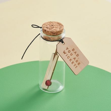 A miniature cricket bat in a glass bottle. Personalised sport themed gift