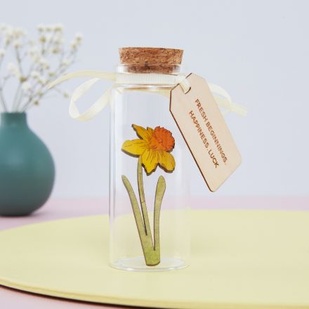 Miniature daffodil in glass bottle with engraved wooden tag