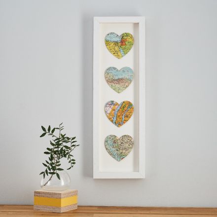Three map hearts in a white frame, portrait orientation.  With printed personalisation 'we met' 'I proposed' and 'we married' printed in sequence under each heart.