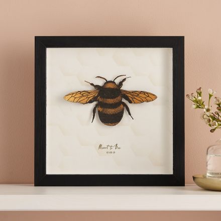 3D paper cut honey bee mounted on white card and framed in black box frame.