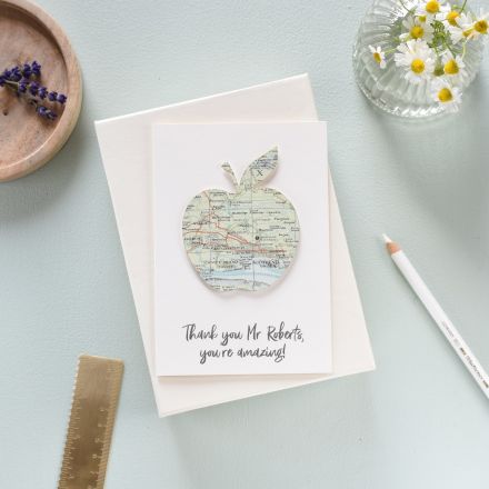 Card with apple silhouette cut from map. Thank you teacher message printed beneath.