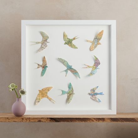 Nine papercut birds made from maps of the world