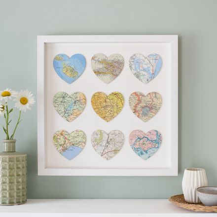 Nine map hearts mounted on white card in white wood box frame.