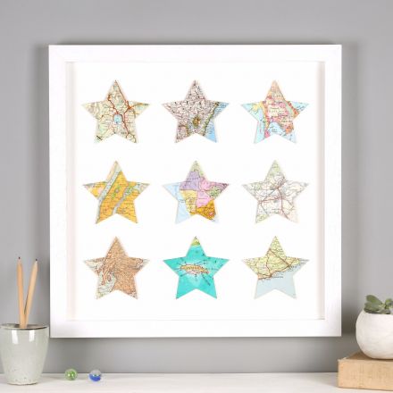 Nine map location stars in white wood frame hung above mantelpiece.