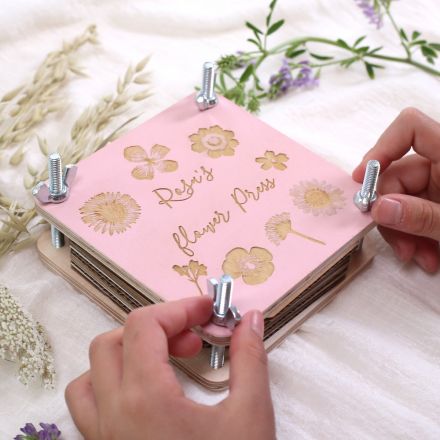 Wooden flower press with 'Rosie's flower press' engraved on the top.