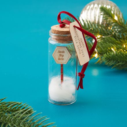 Glass bauble with santa stop here sign