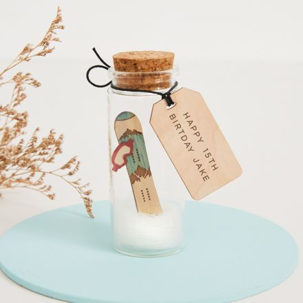 Glass message bottle  with engraved message tag and holding miniature snow board 