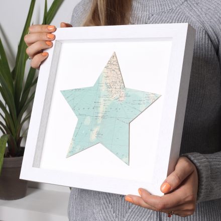 Map star in white wood box frame.
