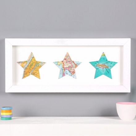 Three map stars in white wood frame, mounted above mantelpiece.
