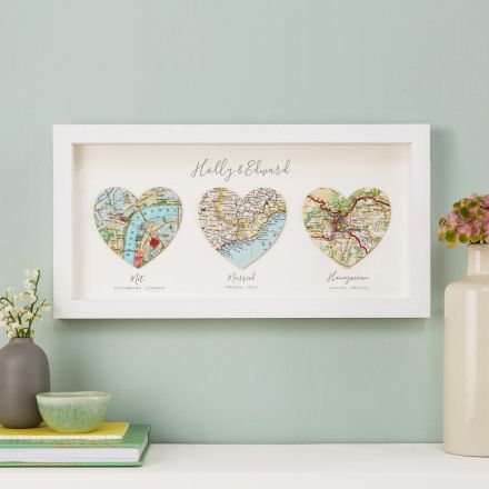 Three map hearts in white wood frame, landscape orientation.  Printed personalisation beneath each heart. 