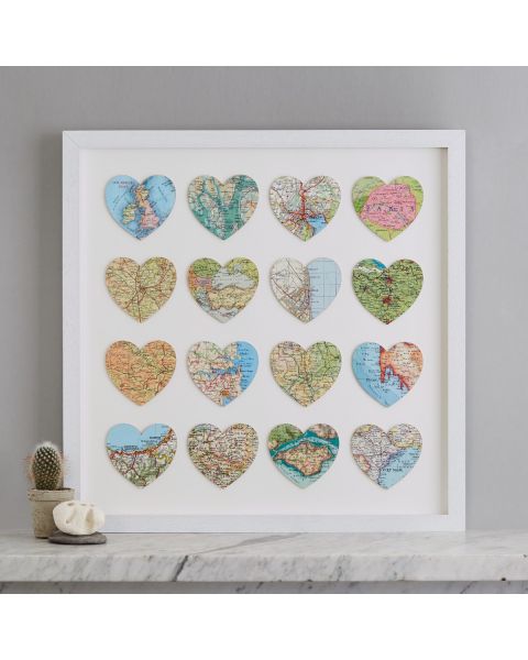 Sixteen personalised map location hearts in white box frame on marble mantelpiece