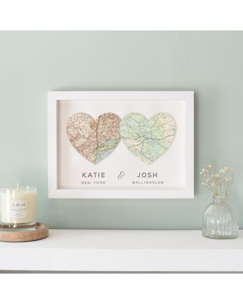 Two map hearts in white wood frame with couples names and date printed beneath.