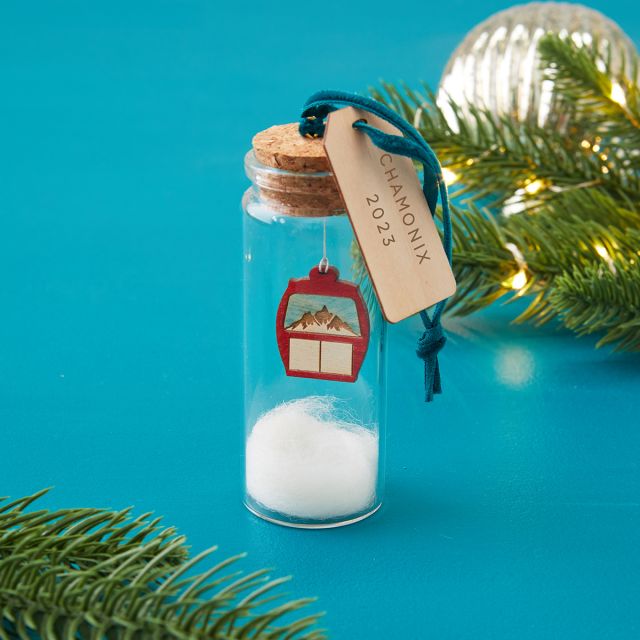 Ski lift inside a miniature glass bottle with engraved tag