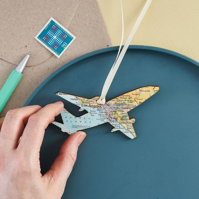 Hanging aeroplane keepsake faced with Los Angeles map and strung with cream ribbon.