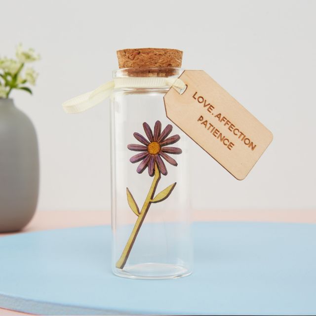 miniature aster flower in glass bottle with engraved message tag