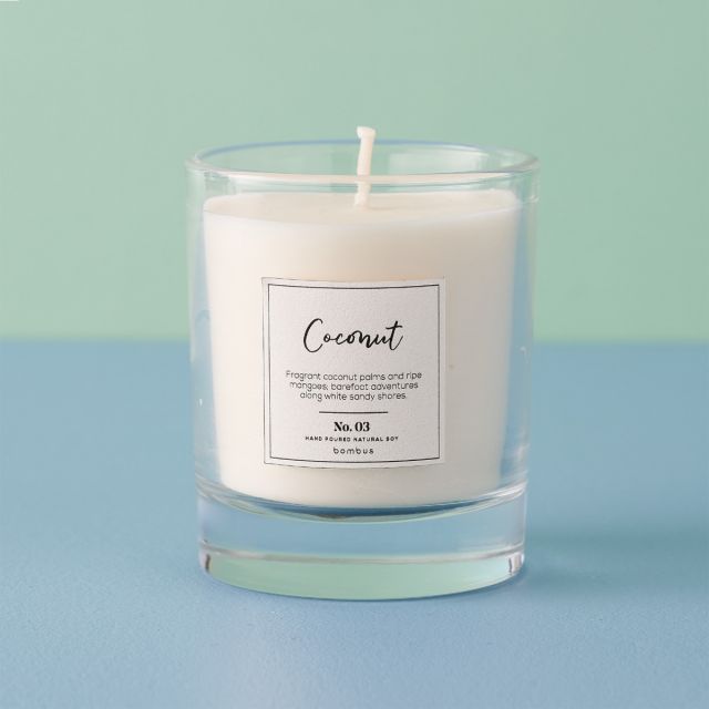 Tropical coconut scented candle in glass jar.