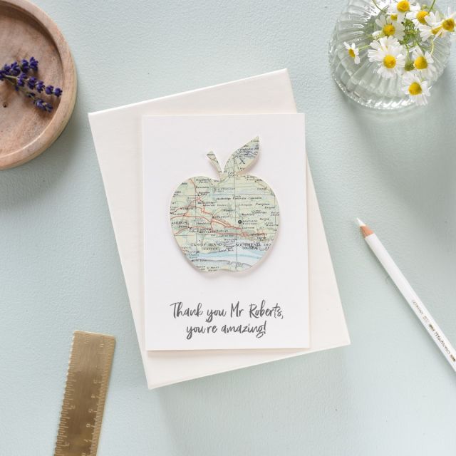 Card with apple silhouette cut from map. Thank you teacher message printed beneath.