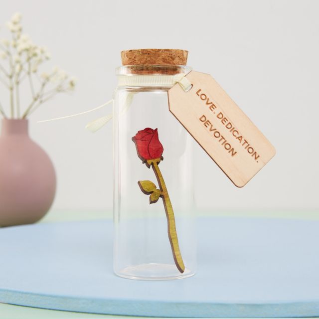 Miniature rose in a glass bottle with wooden engraved message tag.