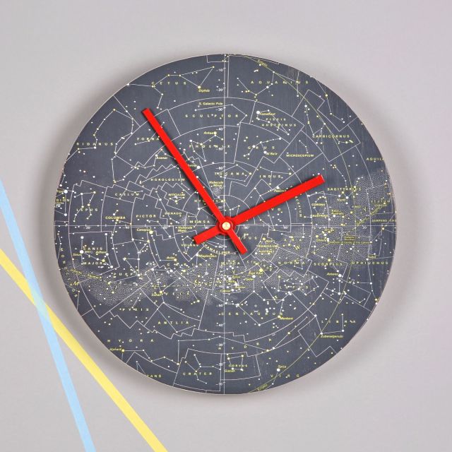 Solid wood round clock faced in original constellation map. Red clock hands.