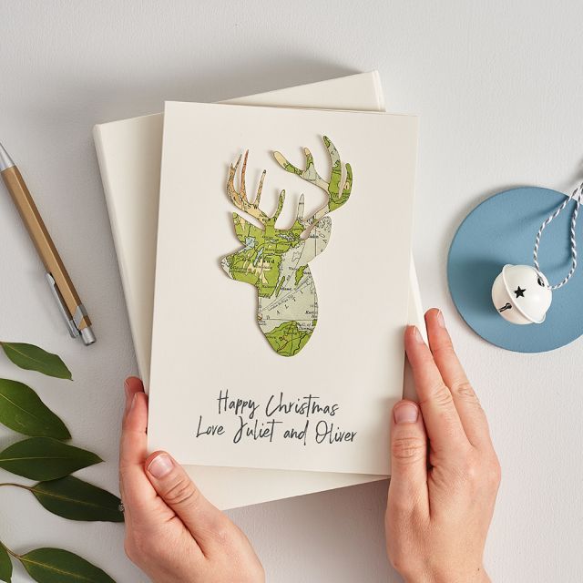 Map stag's head silhouette mounted on white card with 'Happy Christmas' printed below.