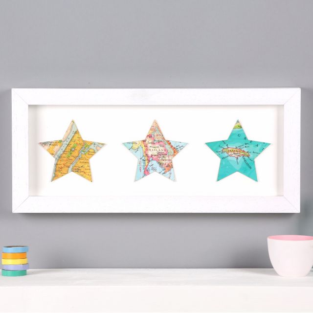 Three map stars in white wood frame, mounted above mantelpiece.