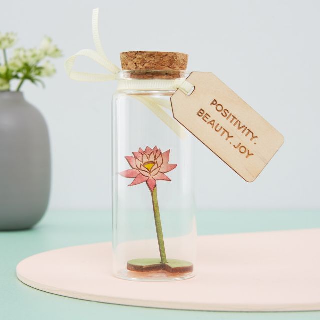 Miniature waterlily in a glass bottle with wooden engraved message tag.